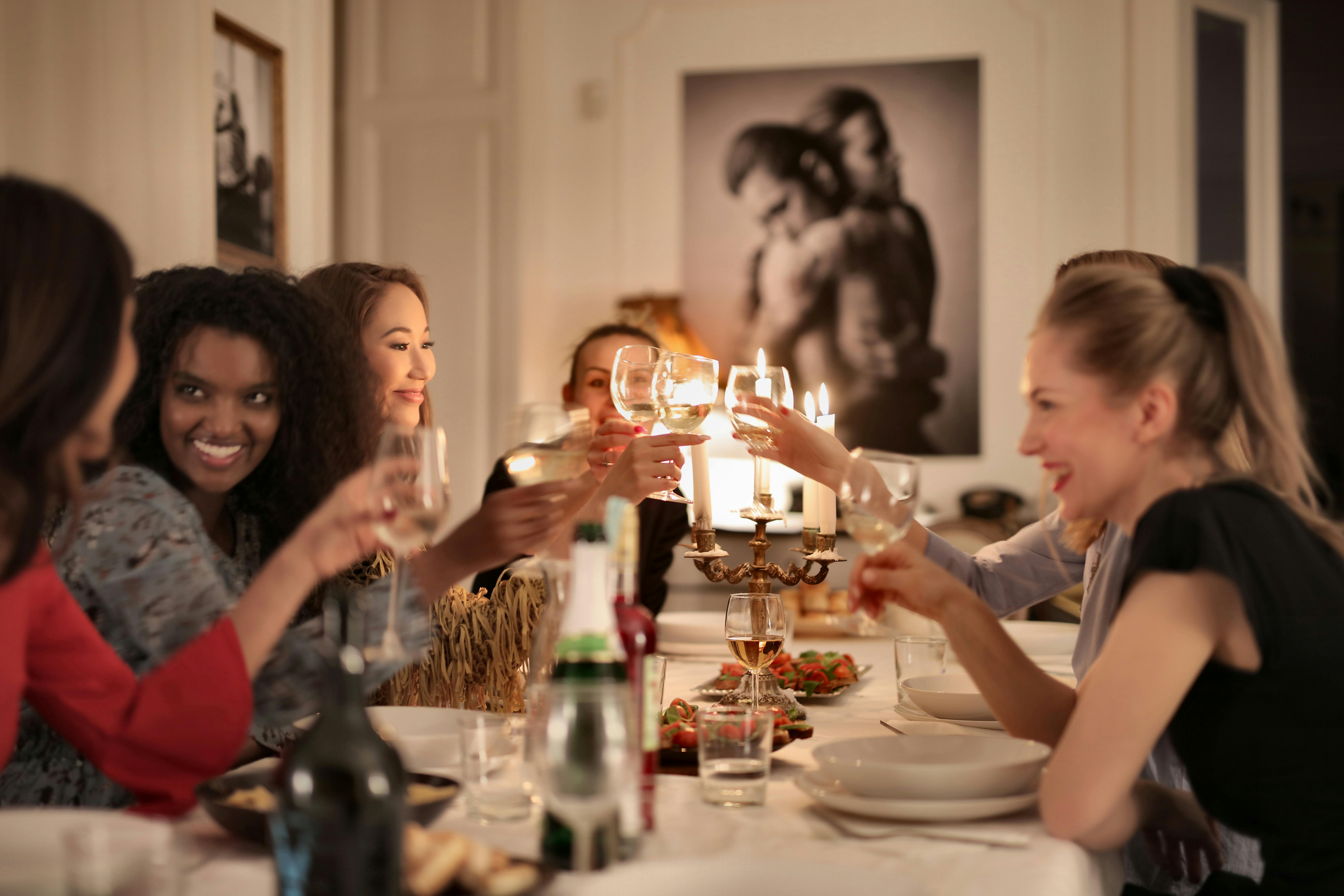 A group toasting around a candlelit dinner table