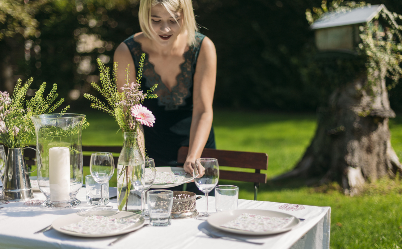 An elegantly set garden table with florals and glassware for a ticketed supper club dinner